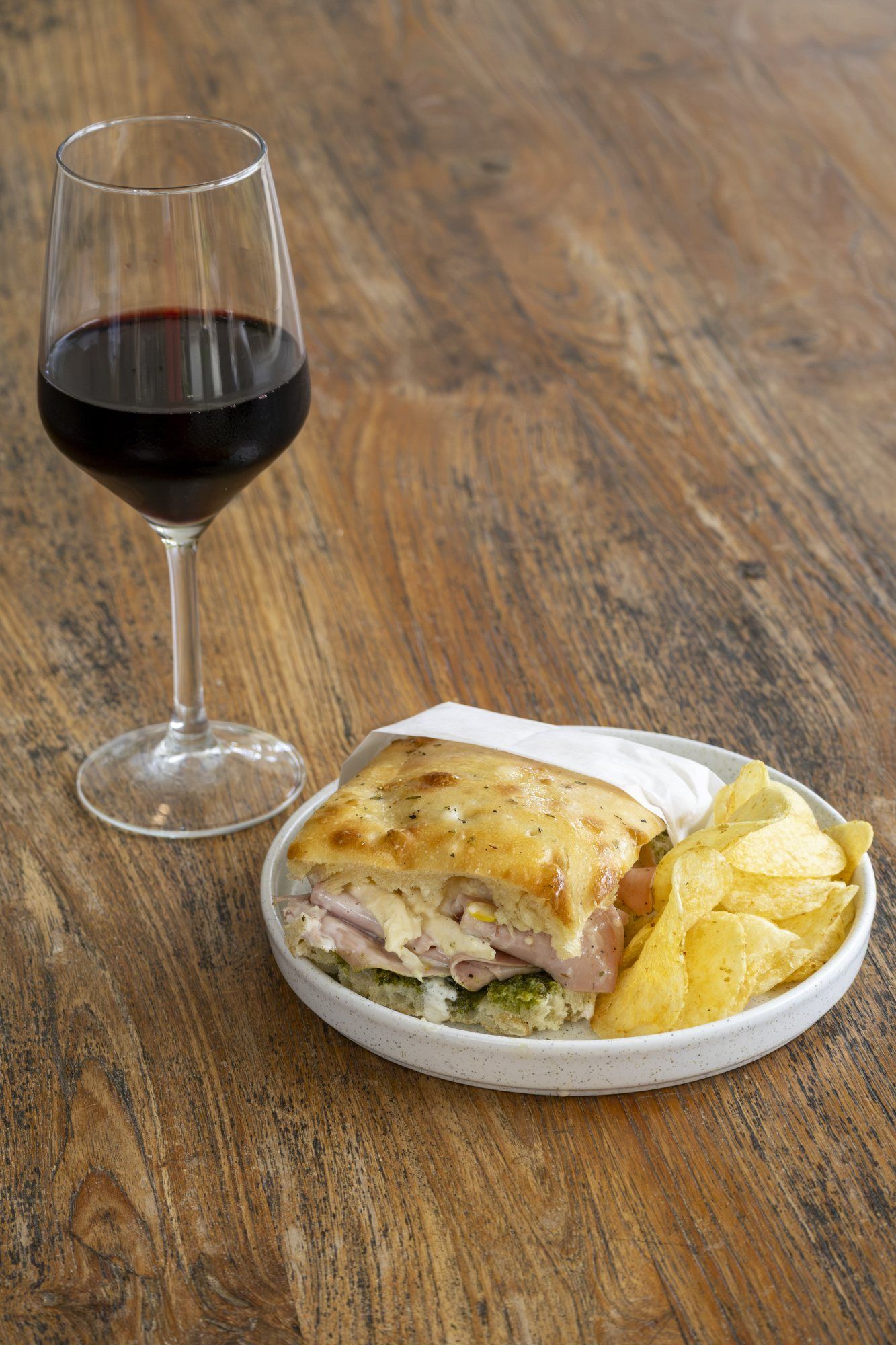 Focaccia, chips and a glass of red wine on a wooden table