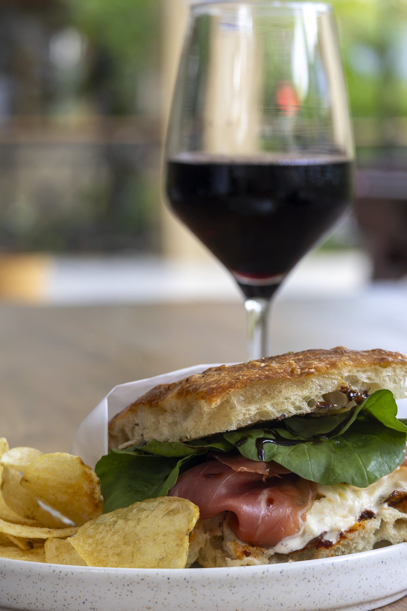 Focaccia sandwich and chips with a glass of wine