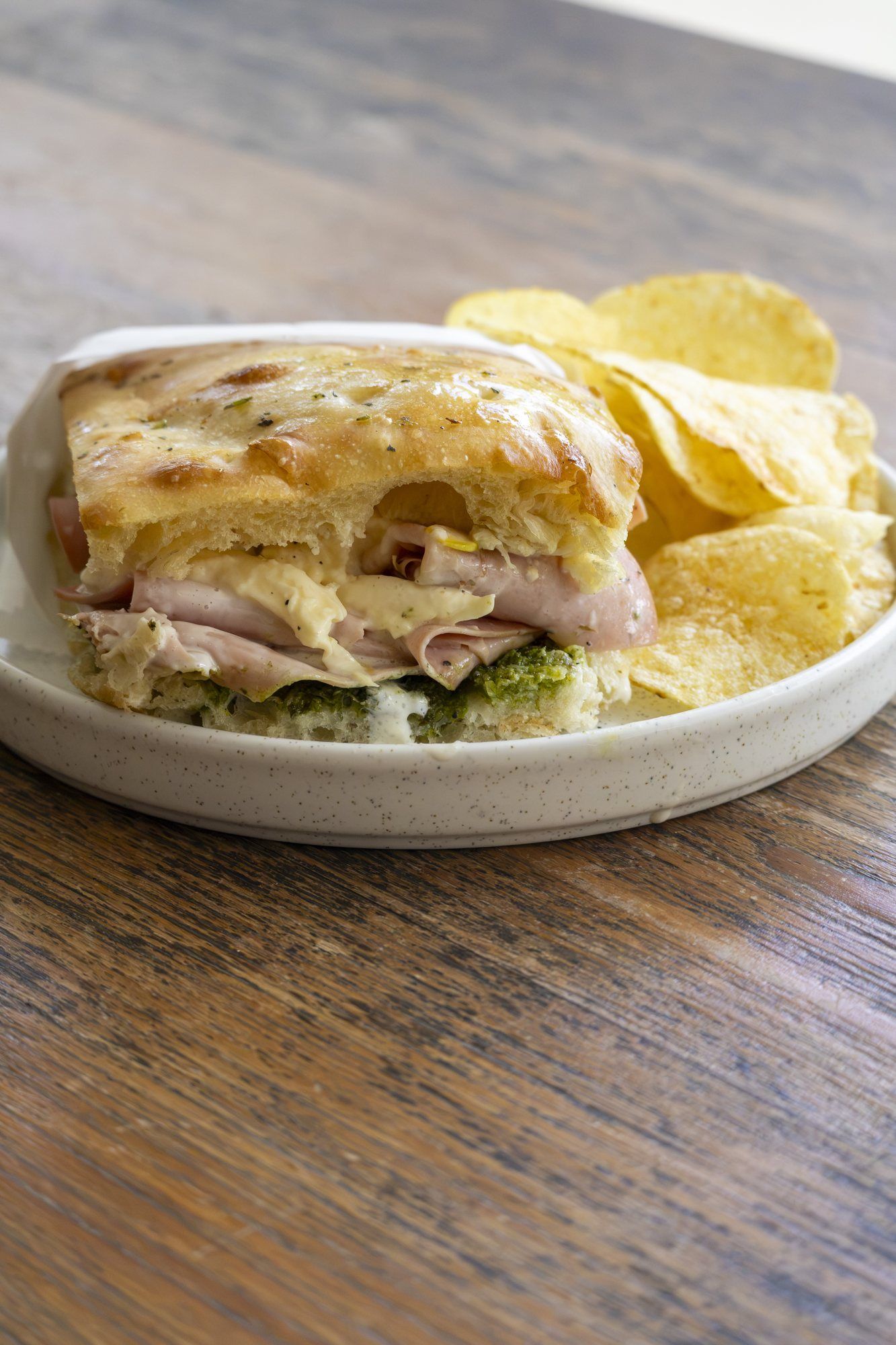 Focaccia sandwich with chips on a wooden table